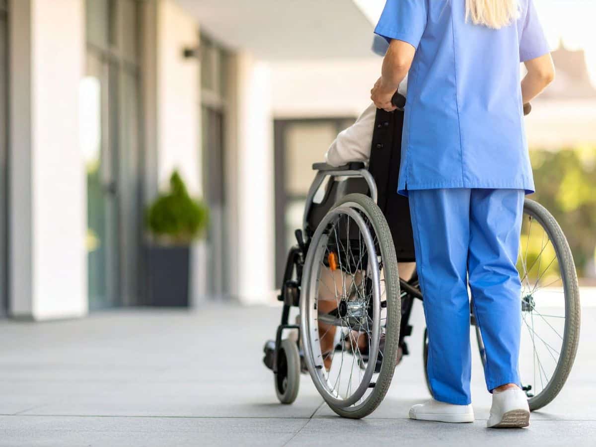 nurse guiding a person in a wheelchair